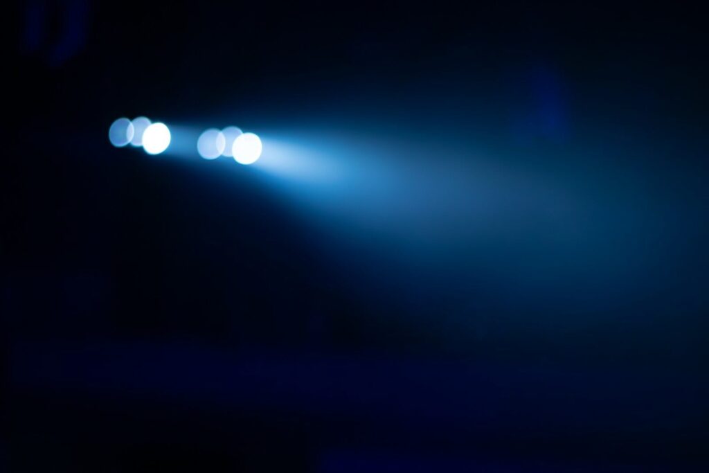 Blue light beam illuminates dark background